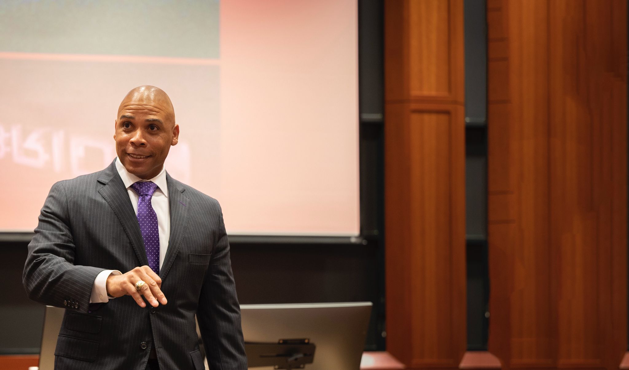 Dr. Hise Gibson speaking to an audience from a lecture hall stage